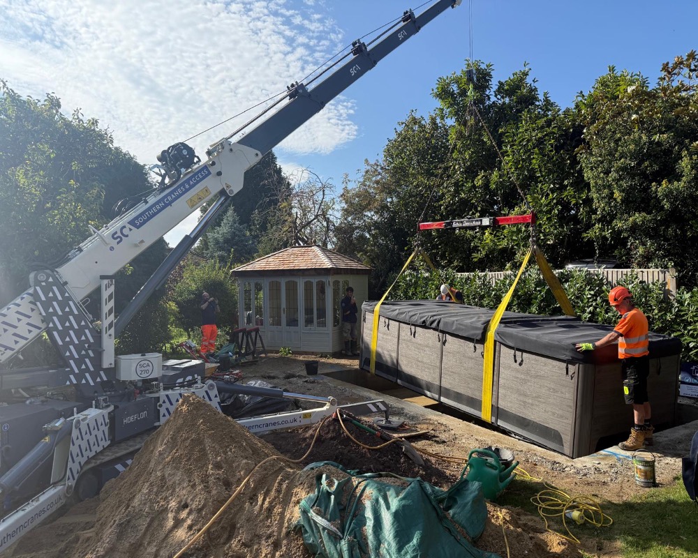 Crane lifting large swim spa into prepared position 