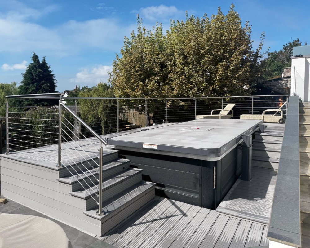 Spa pool with cover on raised decking area with modern balustrade