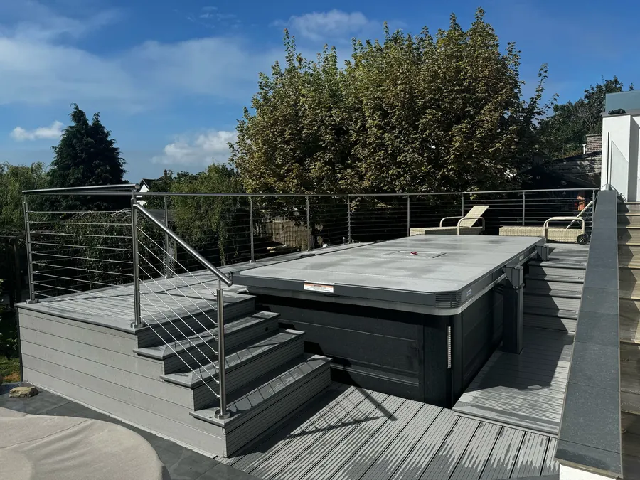 Hot tub on a raised deck with steps and a balustrade